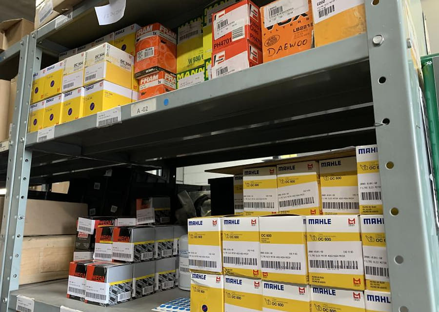 Prateleiras de peças e filtros etiquetados no estoque da KMP Empilhadeiras